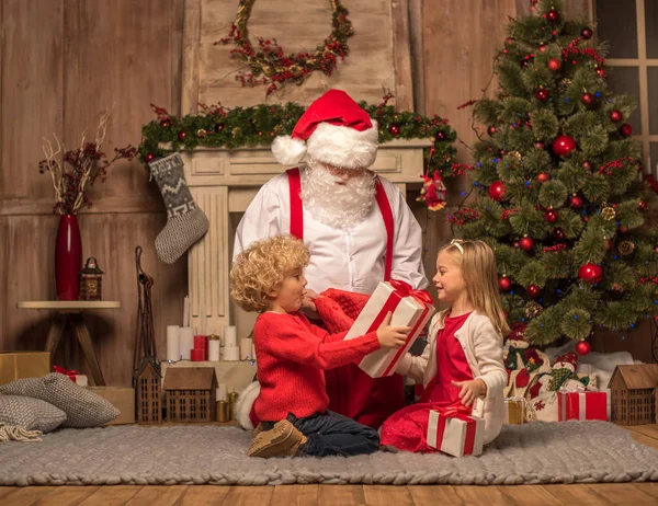 Père Noël et les enfants avec des cadeaux de Noël — Photo