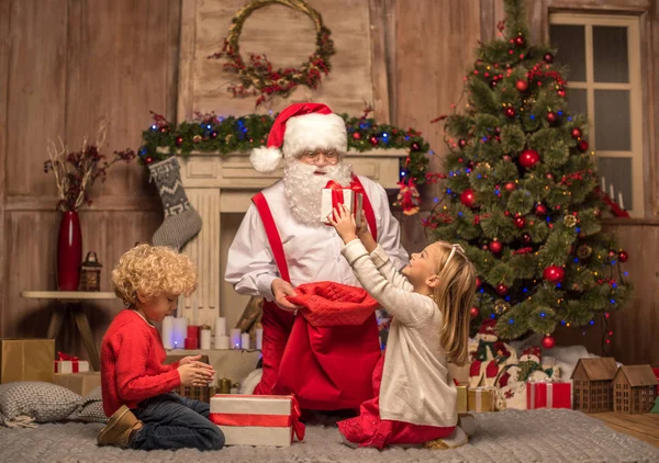 Santa Claus i dzieci z prezenty świąteczne — Zdjęcie stockowe