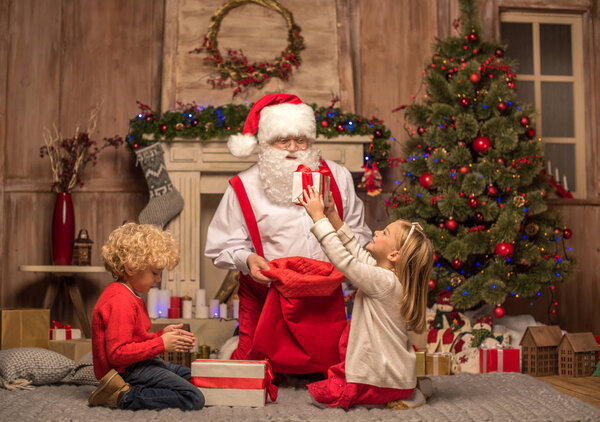 Санта-Клаус и дети с рождественскими подарками
