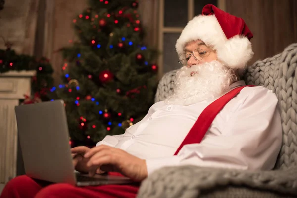 Санта-Клаус с помощью ноутбука — стоковое фото