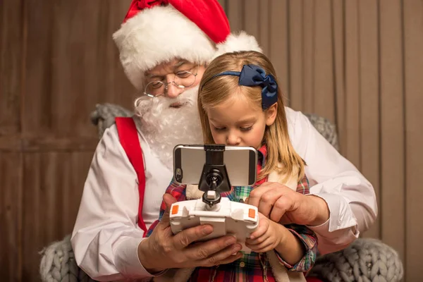 Papai Noel com criança usando drone hexacopter — Fotografia de Stock Grátis