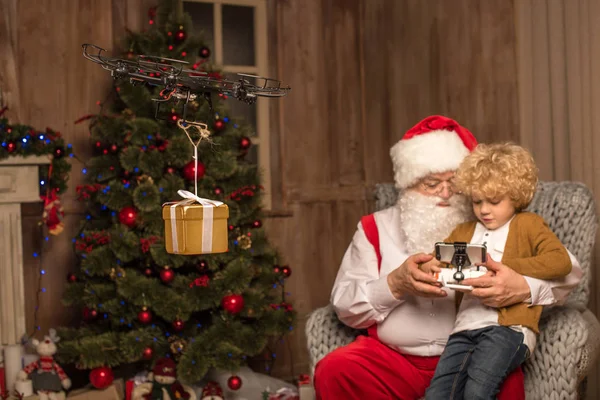 Санта с ребенком с помощью гексакоптера дрона — стоковое фото