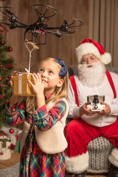 Santa met kind met behulp van hexacopter drone — Stockfoto