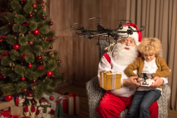 Santa met kind met behulp van hexacopter drone — Stockfoto