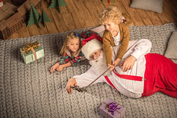 Weihnachtsmann mit Kindern beim Selfie — Stockfoto