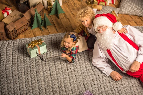 Jultomte med barn pratar selfie — Stockfoto