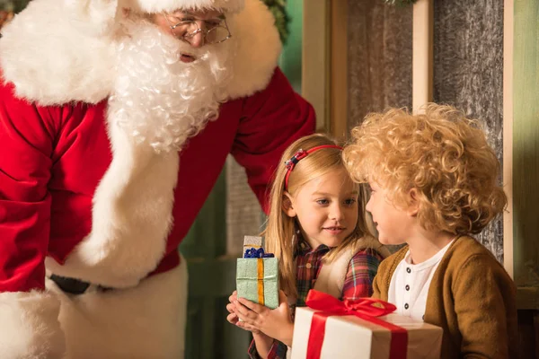 Санта-Клаус и дети с подарочными коробками — стоковое фото