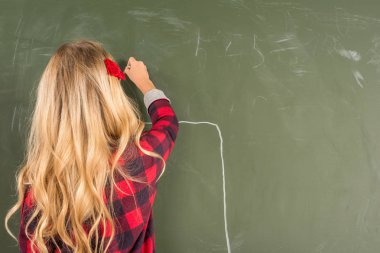Schoolgirl drawing on blackboard clipart