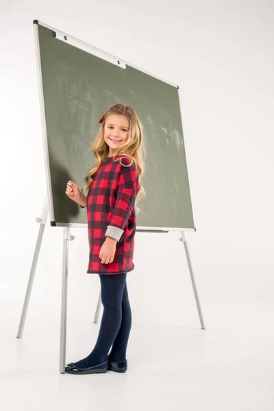 Schoolmeisje staande in de buurt van schoolbord — Stockfoto