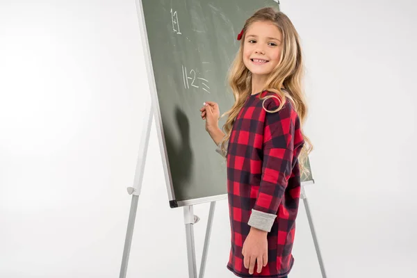 Schülerin steht neben Kreidetafel — Stockfoto