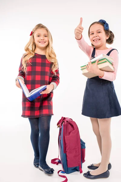 Schoolmeisjes met boeken gebaren — Stockfoto