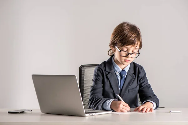 Schulkind im Business-Anzug schreibt Dokumente — Stockfoto