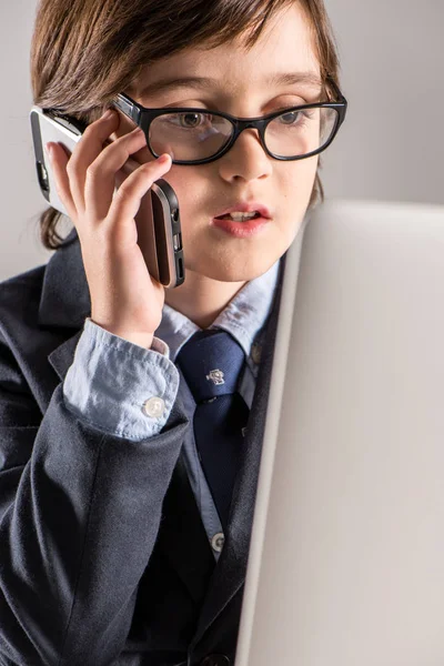 Schulkind im Businessanzug spricht auf Smartphone — Stockfoto