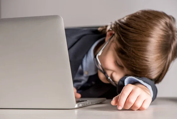 Skolbarn i kostym som sover på skrivbord — Stockfoto