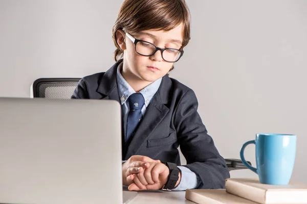 Niño de escuela en traje de negocios mirando smartwatch — Foto de Stock