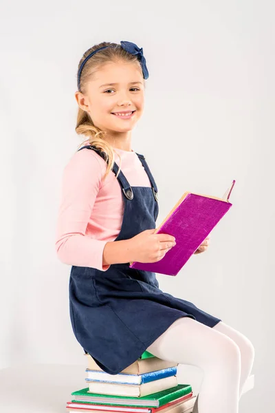 Усміхнена школярка тримає книгу — стокове фото