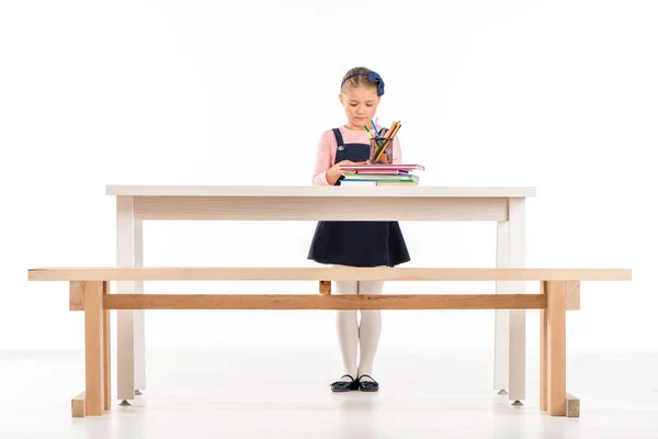 Vážné školačka postavení na stůl — Stock fotografie