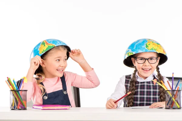 Školačky s půlky zeměkoule na hlavy — Stock fotografie
