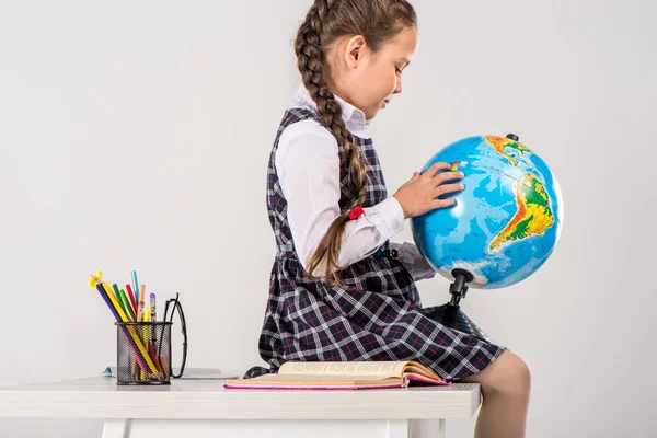 Schoolgirl using globe — Stock Photo, Image