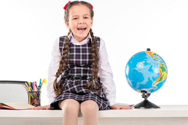 Happy schoolgirl sitting  with globe 