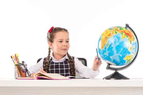 Školačka dělat domácí úkoly a pomocí globe — Stock fotografie