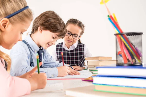 Kinderen schrijven in notitieboekjes — Stockfoto