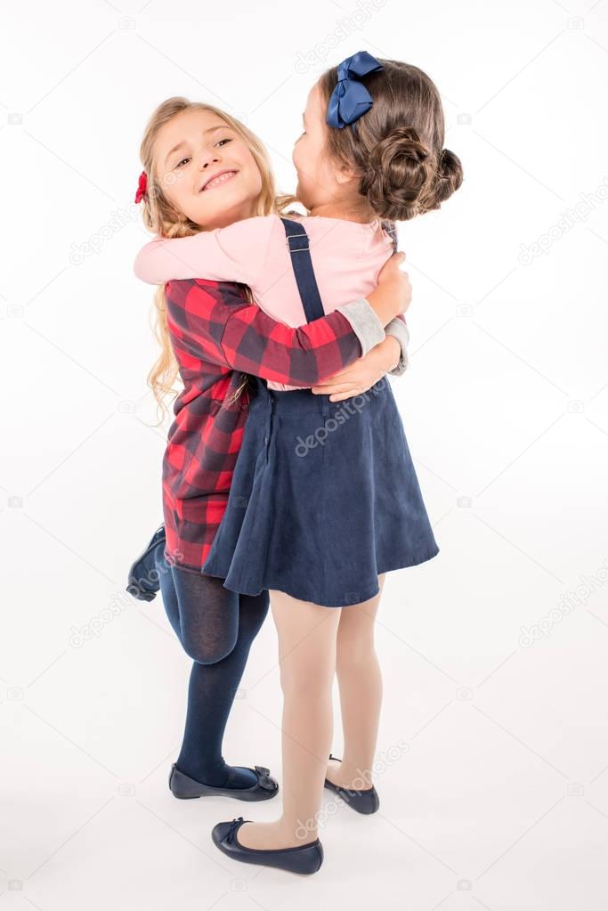 Happy schoolgirls hugging 