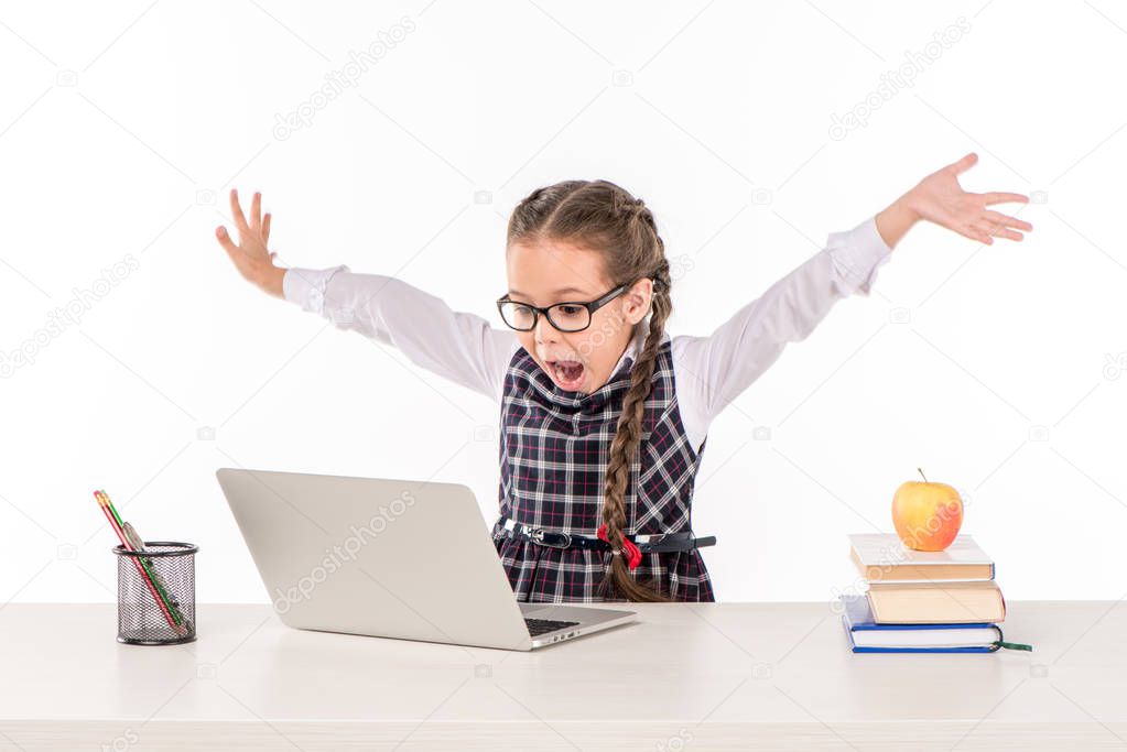 Schoolgirl at desk with laptop