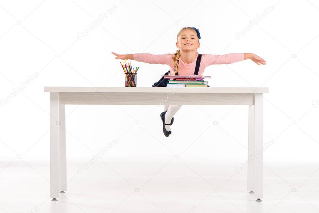 Cheerful schoolgirl lying on desk