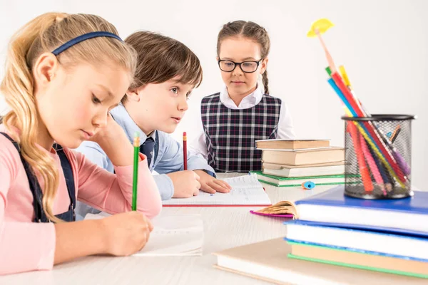 Kinderen schrijven in notitieboekjes — Stockfoto