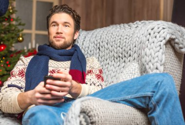 Sandalyede oturan kazaklı yakışıklı adam