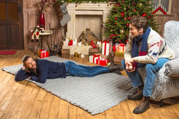 Männer unterhalten sich im Zimmer mit Weihnachtsgeschenken — Stockfoto