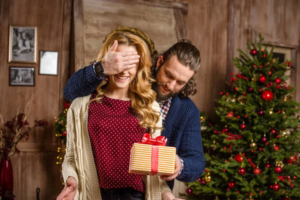 Мужчина дарит подарок женщине на Рождество — стоковое фото