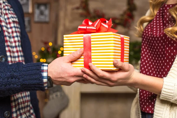 Paar hält Weihnachtsgeschenk in Händen — Stockfoto