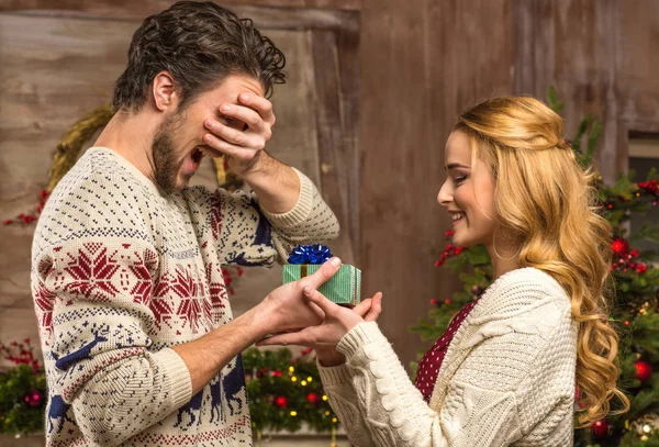 Mulher dando presente de Natal ao homem — Fotografia de Stock