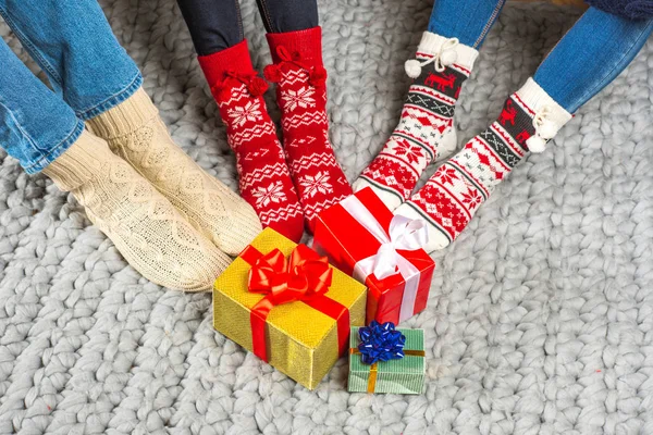 Pierna de mujer en calcetines rojos de navidad sobre fondo azul aislado.