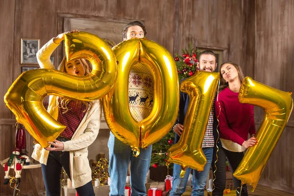 Happy people with golden balloons — Stock Photo, Image