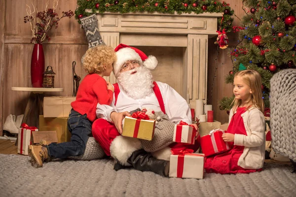 Papá Noel y los niños con regalos de Navidad - foto de stock