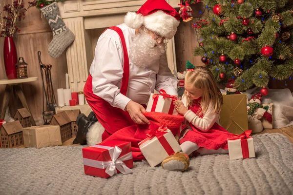 Santa Claus mostrando regalos de Navidad - foto de stock