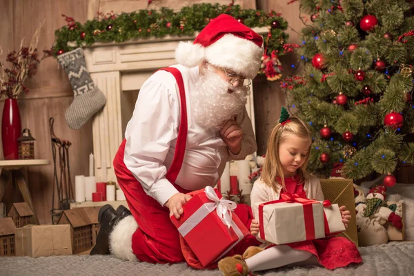 Santa Claus mostrando regalos de Navidad - foto de stock