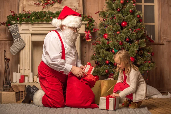 Santa Claus mostrando regalos de Navidad - foto de stock