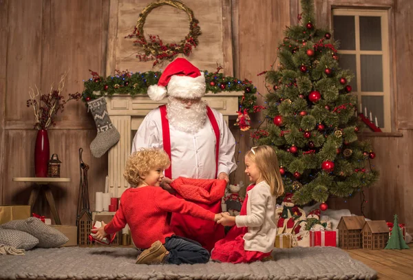 Weihnachtsmann zeigt Weihnachtsgeschenke — Stockfoto