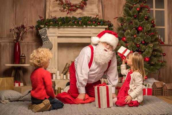 Père Noël et les enfants avec des cadeaux de Noël — Photo de stock