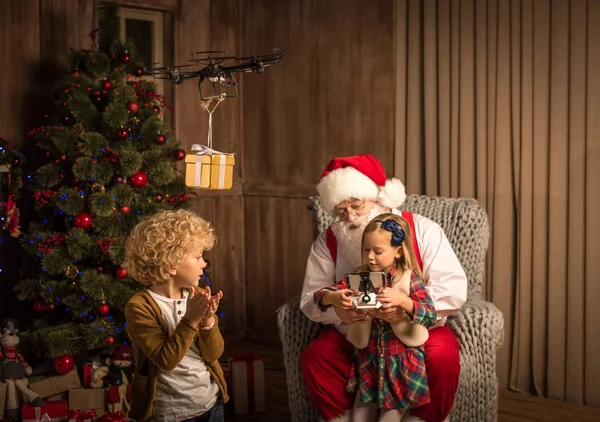 Père Noël avec des enfants utilisant un drone hexacopter — Photo de stock