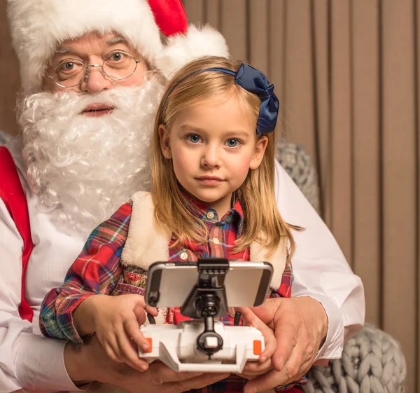 Санта Клаус с ребенком, смотрящим в камеру — стоковое фото
