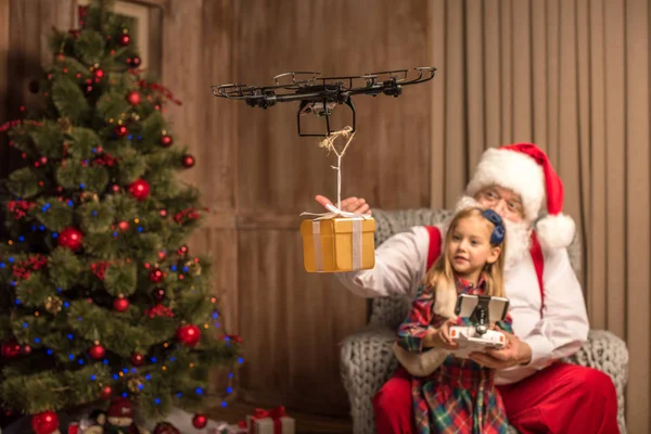 Père Noël avec enfant utilisant un drone hexacopter — Photo de stock