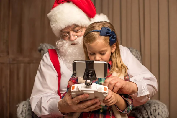 Papai Noel com criança usando drone hexacopter — Fotografia de Stock