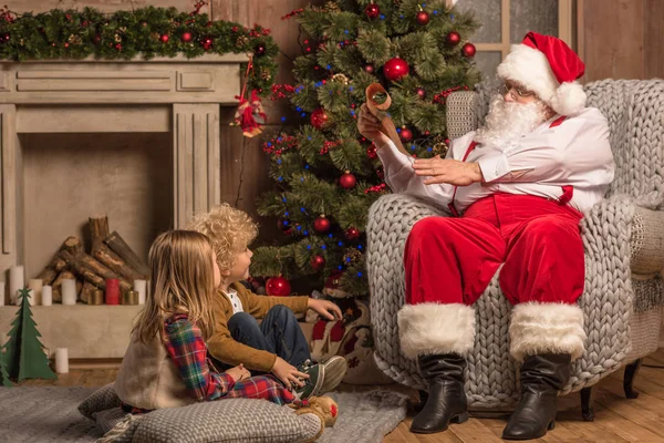 Santa Claus con niños leyendo la lista de deseos - foto de stock