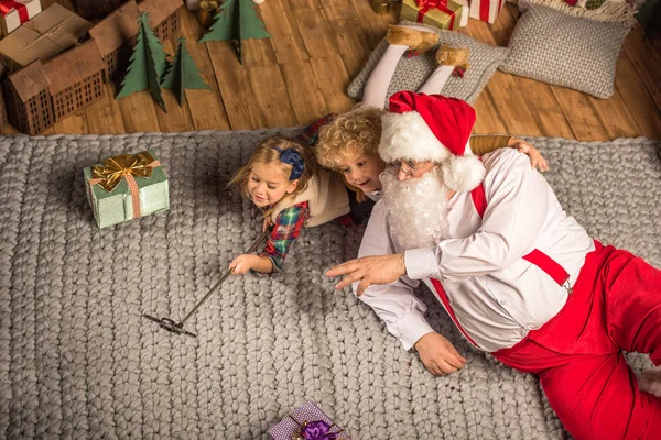 Père Noël avec des enfants prenant selfie — Photo de stock