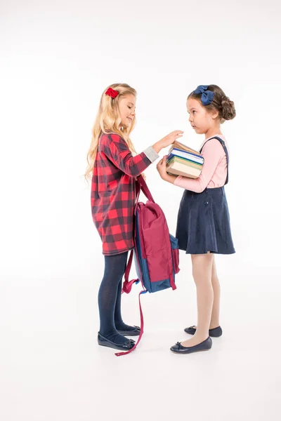 Colegialas sonrientes de pie con libros - foto de stock